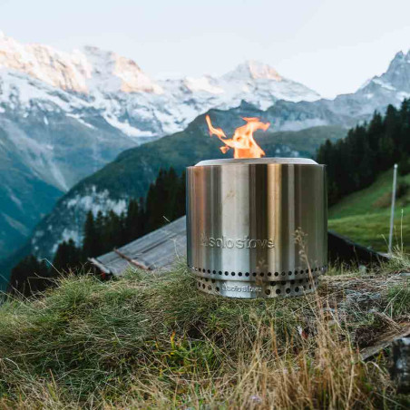 Brasero Bonfire 2.0 Inox Solo Stove posé sur un terrain d'herbe dans les montagnes