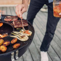 Cuisson d'aliments sur la plancha demi-lune en fonte émaillée du brasero Bowl 57 Höfats