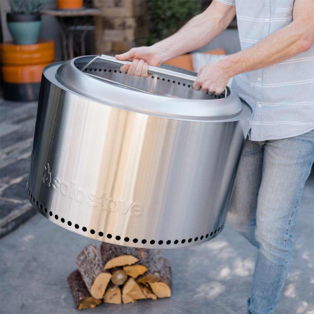 Personne portant le brasero Yukon avec la poignée en inox Solo Stove