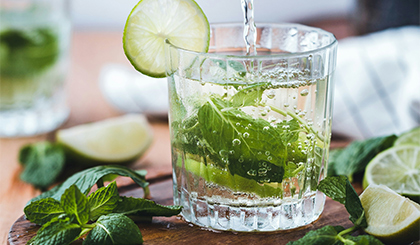 Verre de mojito avec des feuilles de menthe  posées à côté