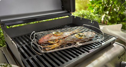 Poisson entier cuit dans un panier de cuisson au barbecue