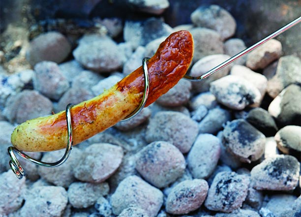 Cuisson d'une saucisse avec le bâton Esschert sur un brasero