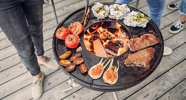 Préparation aliments sur la plancha demi-lune en fonte émaillée sur le brasero Bowl 57 Höfats