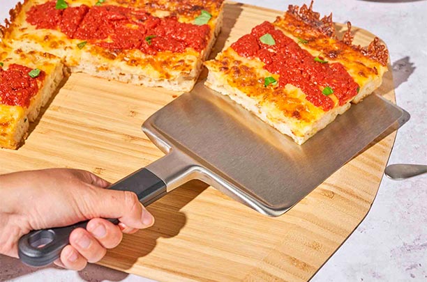 Service d'une part de pizza avec la spatule Detroit Ooni