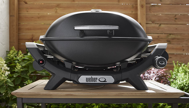 Barbecue gaz Q 2100 N noir Weber sur une table extérieure