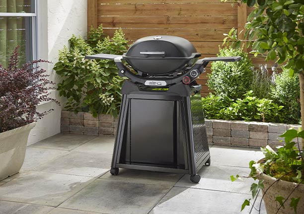 Barbecue gaz Weber sur chariot Q 2800 N + noir sur une terrasse en carrelage