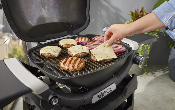 Cuisson d'aliments sur les grilles en fonte émaillée du barbecue gaz Q 1200 N noir Weber